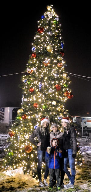 (From left) Parker O'Brien, 17, Kelsye Cates, Mason Cates, 6, and Spencer O'Brien have their photo taken in front of Fernley's Christmas tree.