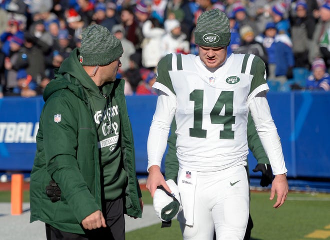 New York Jets quarterback Sam Darnold is escorted toward the tunnel to leave the field during the first half of an NFL football game against the Buffalo Bills, Sunday, Dec. 9, 2018, in Orchard Park, N.Y. (AP Photo/Adrian Kraus)