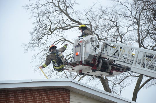 A firefighter falls from the ladder truck platform as he climbs on the roof to fight a fire at a Springfield home Monday, Dec. 10, 2018. He was not injured.