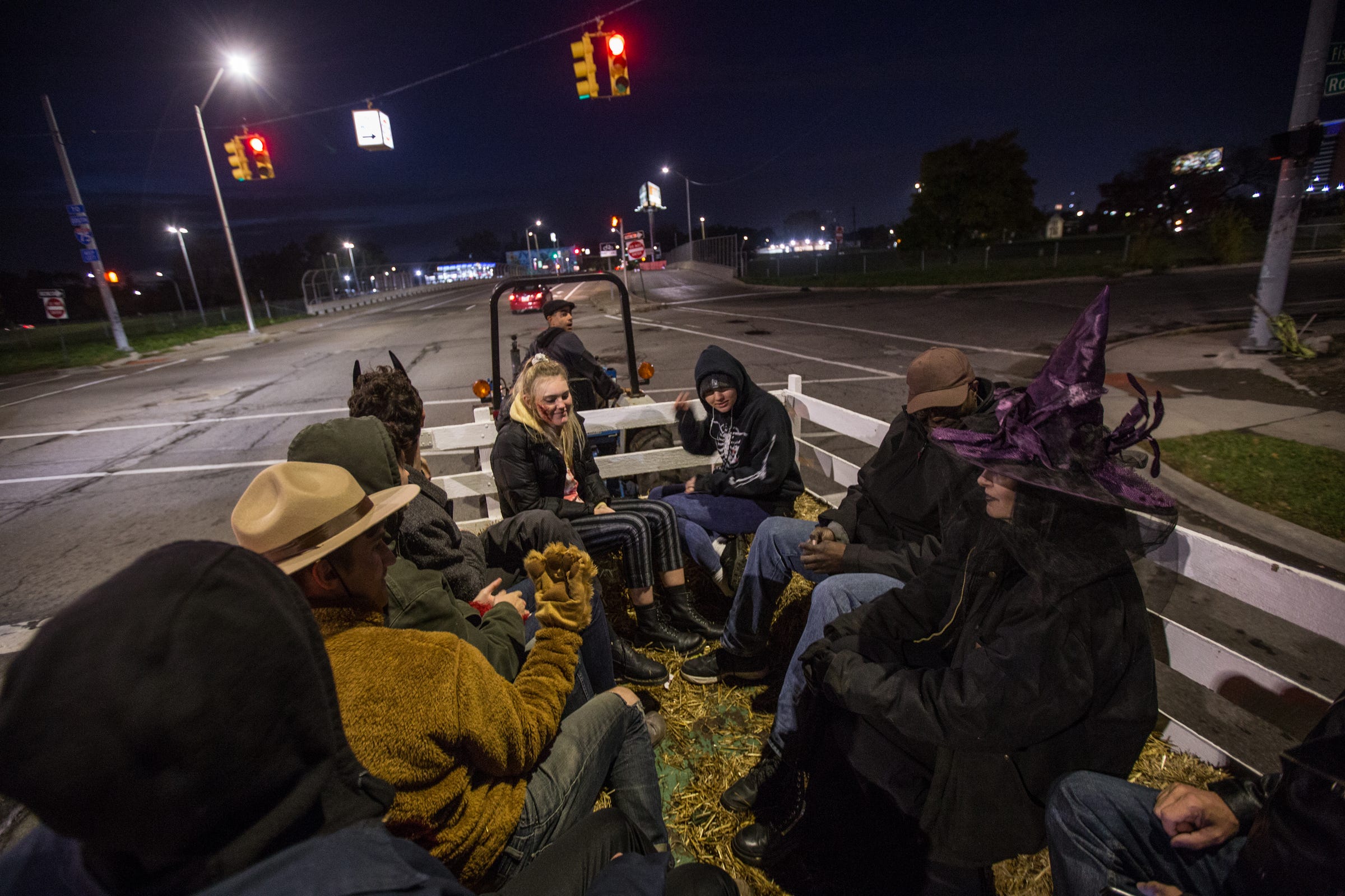 Kristyn Koth (right) of Detroit and her daughters Sojourner Posch (center left) and Pepiot Posch (center right) ride along in a hayride being driven by neighbor Greg Willerer through Detroit's Corktown neighborhood on Thursday, Oct. 31, 2018.