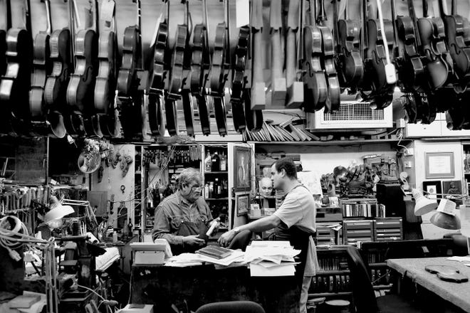 Israeli violin makers and restorers Amnon Weinstein and his son Avshalom Weinstein among the violins in their workshop.