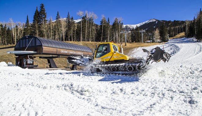 Machine-made snow is spread around near the Grand Canyon Express chairlift, Thursday, November 15, 2018, at Arizona Snowbowl.