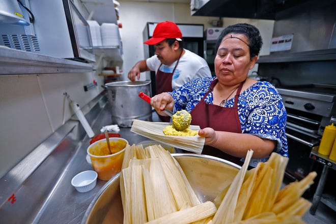 Maria Vasquez fills tamales she is making as her son Adrian Vasquez, left, helps with the process, at Pico de Gallo restaurant, Tuesday, Dec. 11, 2018.  The family is making the traditional food for the Carmel Farmer's Market. 
