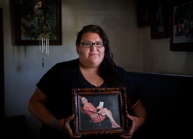 In this July 13, 2018, file photo, Kimberly Loring holds a photo of her sister, Ashley HeavyRunner Loring, who went missing on the Blackfeet Indian Reservation as she stands in her grandmother's home in Browning, Mont. Loring, the sister of a missing Blackfeet woman in Montana is expressing frustration over police's initial response to her loved one's disappearance, telling U.S. senators in prepared testimony Wednesday, Dec. 12, 2018, that "dysfunctional" investigations into missing persons cases have troubled numerous Native American families.