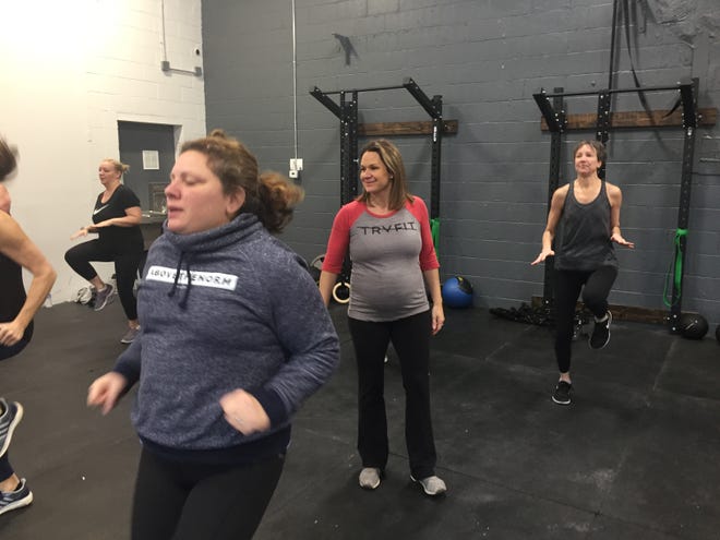 In this photo from Thursday, Dec. 13, 2018, TRV|FIT Fitness Pinckney owner Jennifer Cooke, center, teaches a high-intensity boot camp workout class in her  space at 211 Main Street in Pinckney. From left, Andi Bissett, Linda Schnieder and Mary Serino feel the burn.