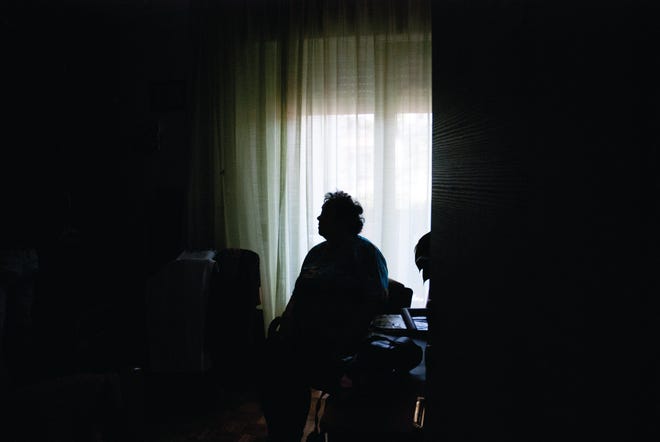 Senior Woman Alone in Dark Room.