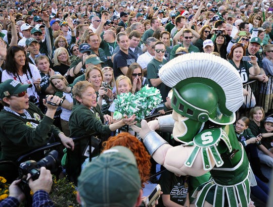 MSU mascot Sparty hands a green rose to MSU alum Joyce Jilg as 27,000 Spartan fans gather at a Rose Bowl pep rally in downtown Los Angeles on Dec. 31, 2013. More than years later, MSU fans long for a similar buzz.