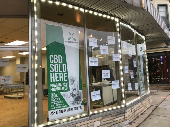 Michelle La Count (raising a panel on a side window) readies Waukesha's first CBD dispensary store, Full Spectrum Holistic Healing. The business plans to open a second location in Whitefish Bay.