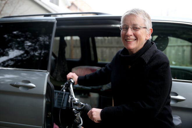 Jean Brougher stands will her bicycle and minivan which she will travel with as she volunteers at an animal shelter near Paradise, California following wildfires. Photographed at Brougher's home in Salem on Friday, Dec. 14, 2018.