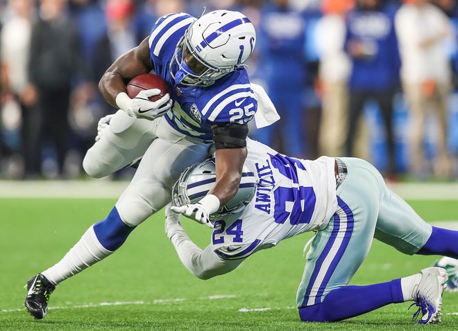 Dallas Cowboys cornerback Chidobe Awuzie (24) tackles Indianapolis Colts running back Marlon Mack (25) in the first half of the game at Lucas Oil Stadium in Indianapolis, Sunday, Dec. 16, 2018.