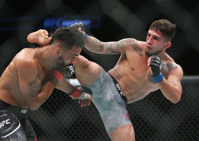 Sergio Pettis (right) connects with a kick to the side of Rob Font's head during their 135-pound bout in Milwaukee.