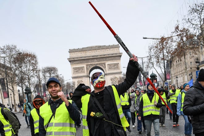 French people protest the rising costs of living by the Arc de Triomphe in Paris, on December 15, 2018.  The "Yellow Vests" (Gilets Jaunes) movement in France started as a protest about planned fuel hikes but has morphed into a mass protest against the president's policies and top-down style of governing.