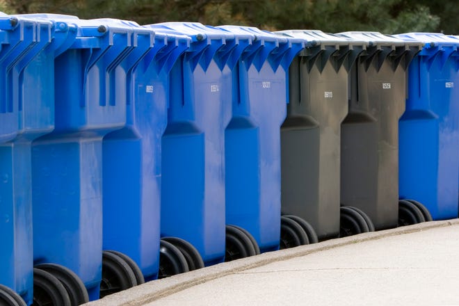 A row of plastic garbage cans.