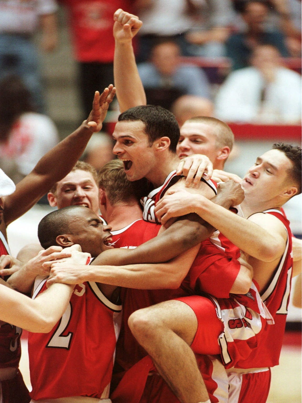 Wisconsin's Mike Kelley, center, celebrates with teammates after beating Purdue 64-60 in the NCAA West finals Saturday, March 25, 2000.