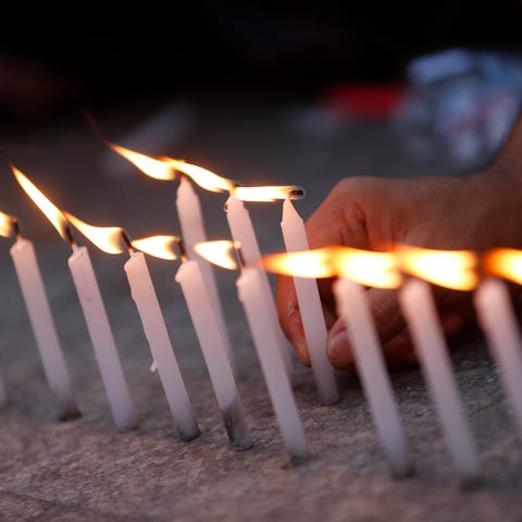 A demonstrator lights candles during a...