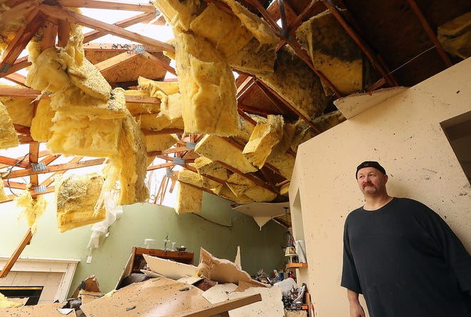 Aaron Crain in the living room of his heavily damaged home on Tiburon Court in Port Orchard on Wednesday, December 19, 2018. 