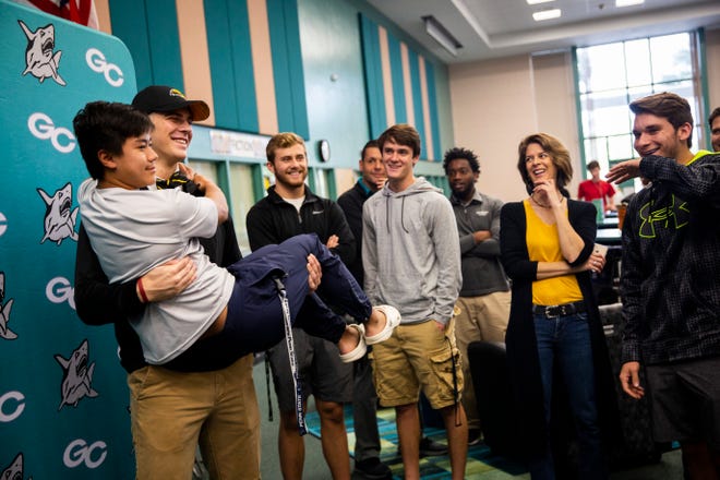 Luke Baker holds Ryan Lai for a photo during the first day of the Football Early Signing Period on Wednesday at Gulf Coast High School. Baker committed to playing football at the University of Southern Mississippi. Teammate Adam Masterson signed with Stetson.