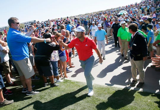 Jon Rahm greets fans while walking towards the 11th tee box at the Waste Management Phoenix Open in Scottsdale, Ariz. Feb. 4, 2018.