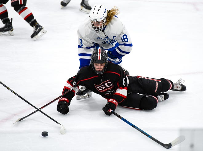 St. Cloud's Eric Warner and Sartell's Jack Hennemann go after the puck during the first period Tuesday, Dec. 18, at the Bernick's Arena in Sartell.