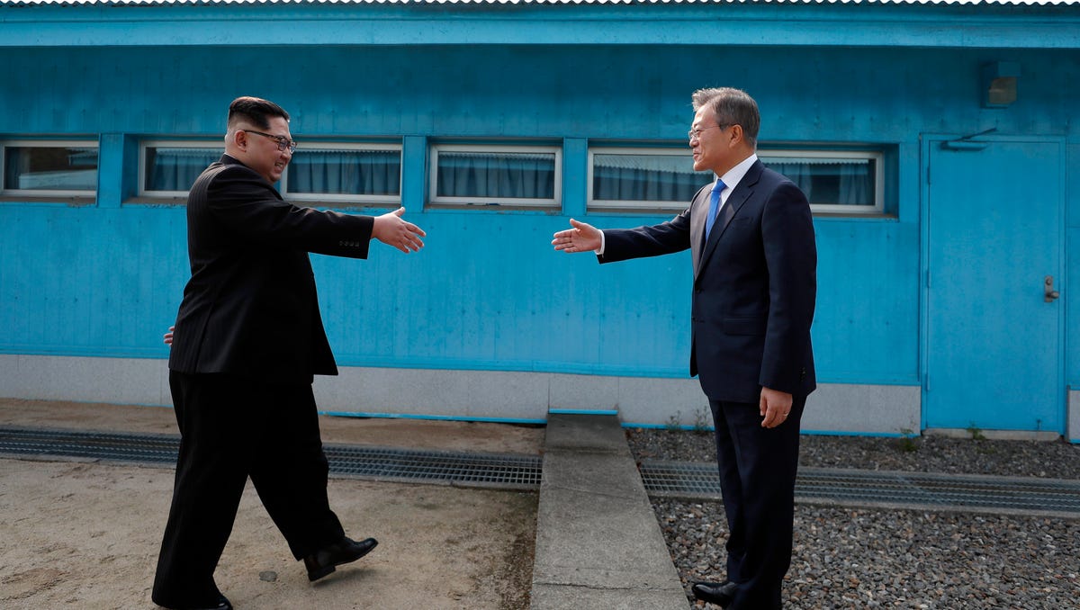 April 27, 2018: North Korean leader Kim Jong-un (L) shakes hands with South Korean President Moon Jae-in (R) between the military demarcation line (MDL), at the Joint Security Area (JSA) on the Demilitarized Zone (DMZ) in the border village of Panmunjom in Paju, South Korea. South Korean President Moon Jae-in and North Korean leader Kim Jong-un are meeting at the Peace House in Panmunjom for an inter-Korean summit. The event marks the first time a North Korean leader has   crossed the border into South Korea since the end of hostilities during the Korean War.