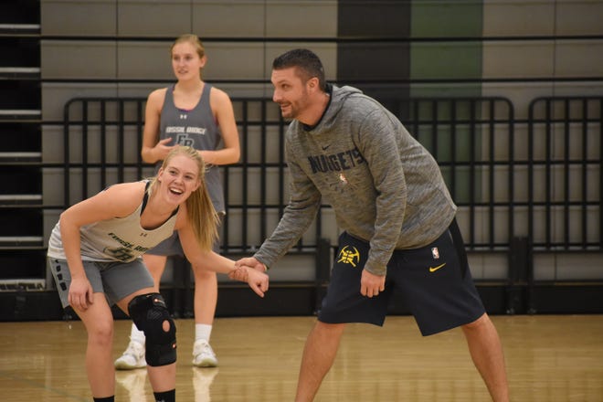 Fossil Ridge girls basketball coach Chad Salz holds a player from running during the team's annual kickball game before the holiday break on Wednesday.