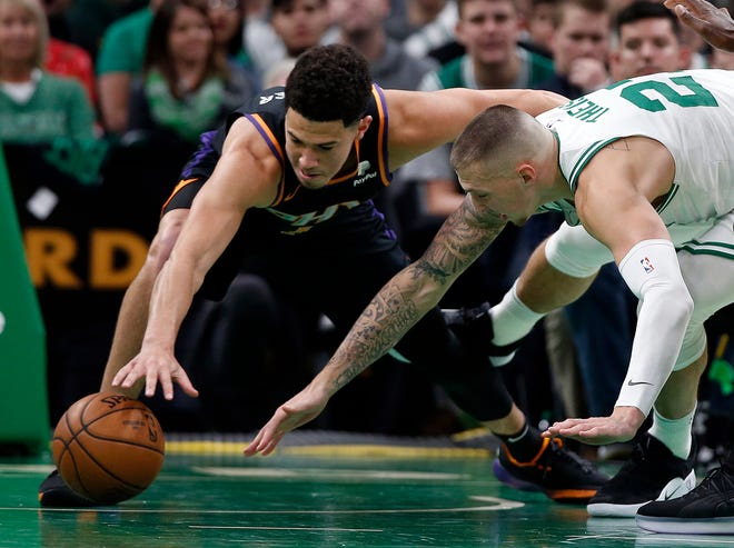 Suns guard Devin Booker and Celtics forward Daniel Theis dive for a loose ball during the second quarter of a game Wednesday at TD Garden.