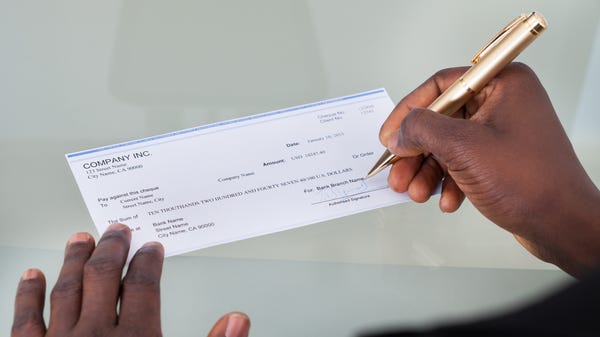 Close-up of a person filling a blank check