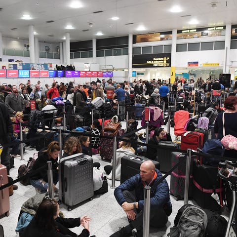 Passengers wait in lines at Gatwick Airport, near 