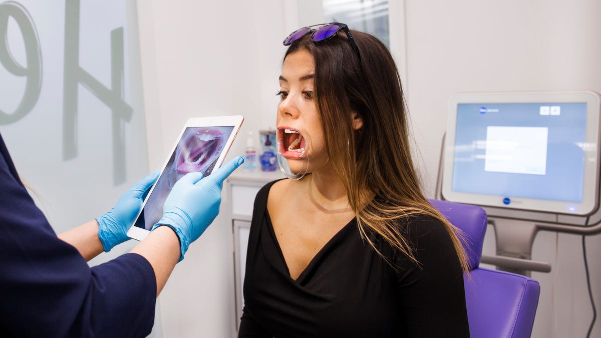 A patient gets her mouth scanned at one of SmileDirectClub's stores. The company provides removable clear-plastic teeth aligners as an alternative to traditional braces.