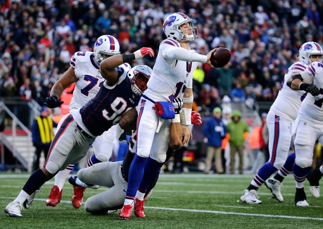 Buffalo Bills quarterback Josh Allen tries to flip the ball to a receiver as New England Patriots defenders Trey Flowers, left, and Lawrence Guy chase him down during the second half of an NFL football game, Sunday, Dec. 23, 2018, in Foxborough, Mass. (AP Photo/Elise Amendola)