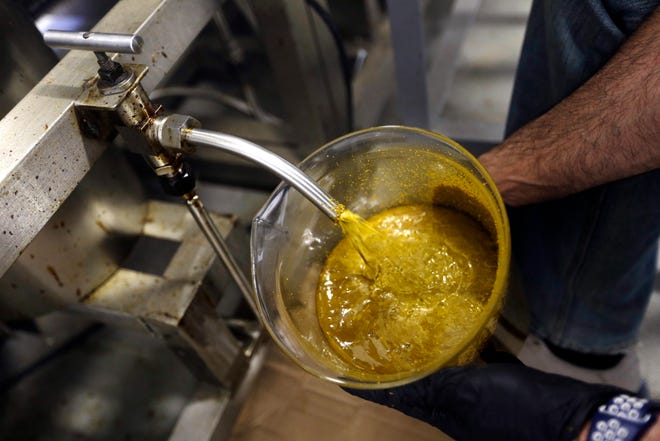 FILE - In this April 24, 2018, file photo, the first rendering from hemp plants extracted from a super critical CO2 extraction device on it's way to becoming fully refined CBD oil spurts into a large beaker at New Earth Biosciences in Salem, Ore. The hemp industry still has work ahead to win legal status for hemp-derived cannabidiol, or CBD oil. The head of the Food and Drug Administration says adding CBD to food or dietary supplements is still illegal. President Donald Trump signed a farm bill this week designating hemp as an agricultural crop, but FDA Commissioner Scott Gottlieb issued a statement saying CBD is a drug ingredient and therefore illegal to add to food or supplements without approval from his agency. (AP Photo/Don Ryan, File)