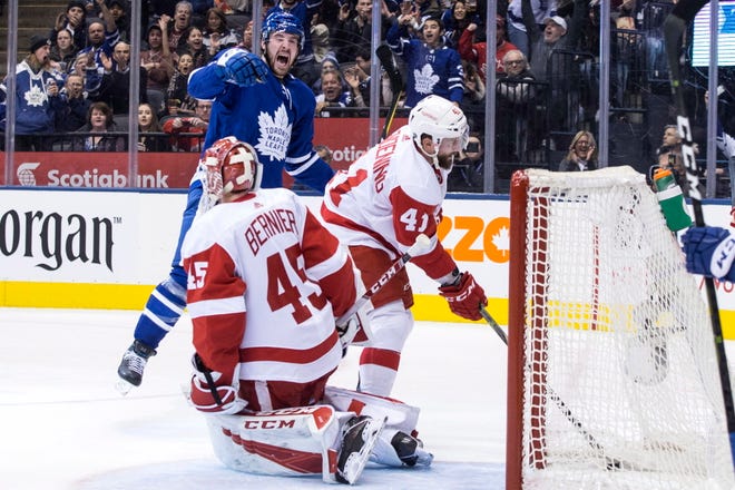 Detroit Red Wings' Luke Glendening (41) retrieves the puck from the net as Toronto Maple Leafs' Frederik Gauthier celebrates after scoring his team's second goal against Red Wings goaltender Jonathan Bernier during second period.