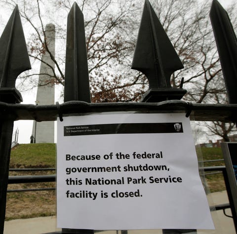 A sign is posted on a fence near an entrance to...
