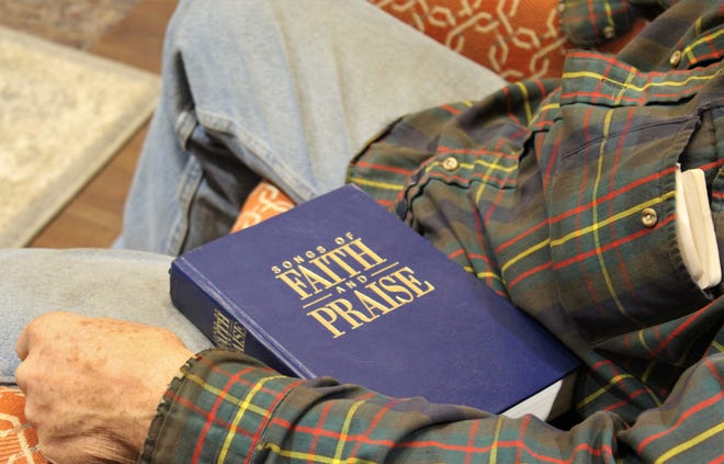 A hymnal rests on the lap of a singer who participated Dec. 20 in singing at Hendrick Hospice Care Enter.