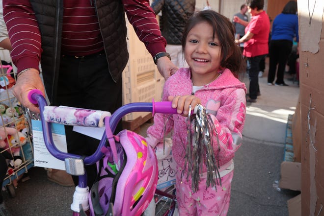 Children receive toys and bikes on Christmas at the Galilee Center in Mecca, Calif., Tuesday, December 25, 2018.