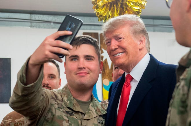 US President Donald Trump takes a photo as he greets members of the US military during an unannounced trip to Al Asad Air Base in Iraq on December 26, 2018. (Photo by SAUL LOEB / AFP)SAUL LOEB/AFP/Getty Images ORIG FILE ID: AFP_1BU3JD