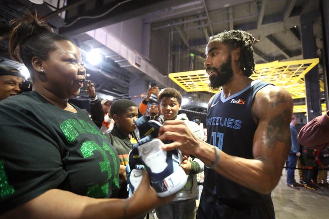 Memphis Grizzlies guard Mike Conley gives his game shoes to Kemberly Lee, mother of Kameren Johnson, the 9-year-old boy who died earlier this month in a bus crash in Arkansas while returning home from a football trip.