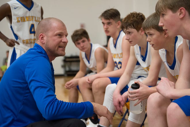 Evansville Christian’s Head Coach Aaron Thompson excites his team during a timeout in the schools first-ever home game against the Cannelton Bulldogs Friday, Dec. 14, 2018.