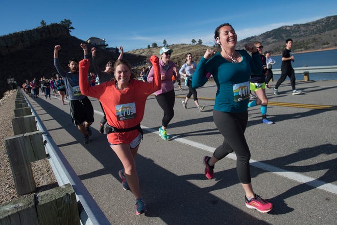 Runners celebrate reaching one mile in the course as they cross Dixon Canyon Dam along Horsetooth Reservoir during the Horsetooth Half Marathon on Saturday, April 14, 2018. 