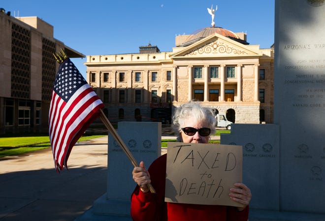 Kathryn Kobor of Phoenix and other protesters voice their opinion against the new $32 vehicle-registration fee at the Arizona state Capitol in Phoenix on Dec. 28, 2018.