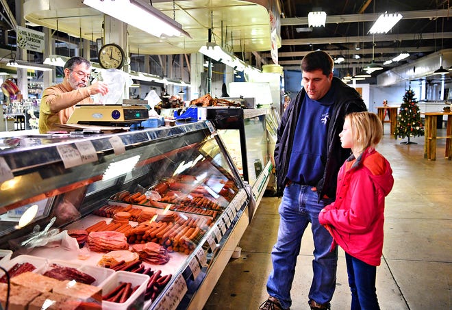 From right, Kearsea Godfrey, 9, and her father Chad Godfrey wait while Matthew Folgleman, of Charles Ilyes Family, Inc., Meats and Produce at Penn Market in York City, Friday, Dec. 28, 2018. Dawn J. Sagert photo