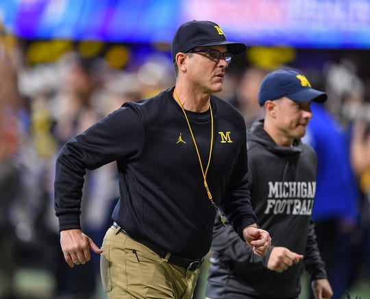 Michigan coach Jim Harbaugh runs off the field before the Peach Bowl on Saturday, Dec. 29, 2018, in Atlanta.