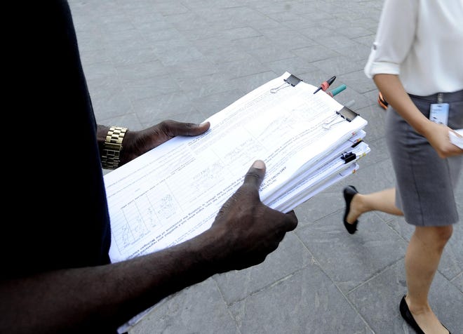 A circulator seeks signatures on a ballot initiative in Detroit.