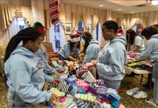 Poughkeepsie City School District students involved with the C.O.L.O.R.S. Foundation prepare holiday gifts for residents of The Pines at Poughkeepsie Center for Nursing and Rehabilitation on Dec. 22, 2018. Through Holiday Helping Hand, a collaboration between the Poughkeepsie Journal and United Way of the Dutchess-Orange Region, the program got $750 to help the community.