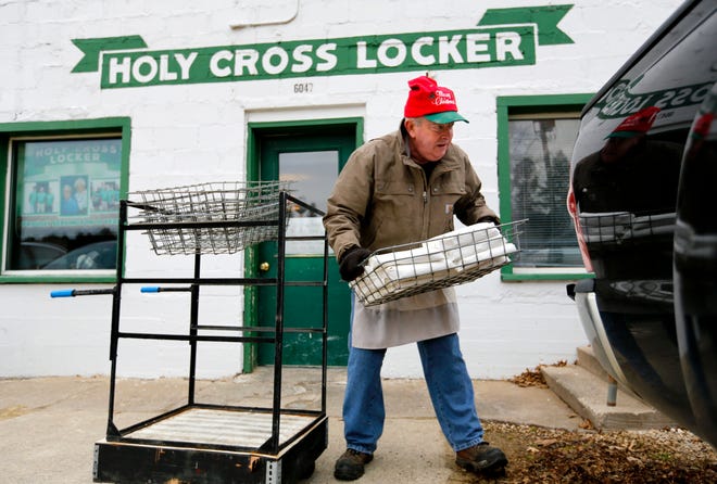 Owner Bob Hayes helps a customer load his meat into a truck at Holy Cross Meat Locker in Holy Cross, Iowa, on Friday, Dec. 21, 2018.