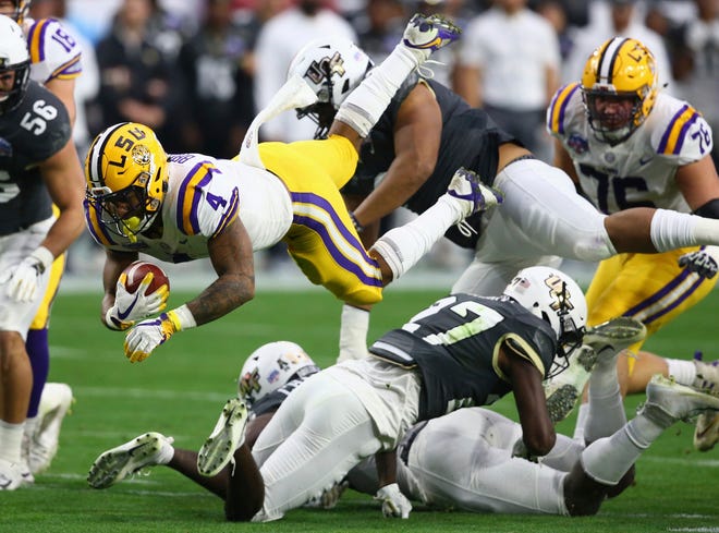 LSU running back Nick Brossette (4) gets upended by UCF defensive back Richie Grant (27) during the first half on Tuesday.
