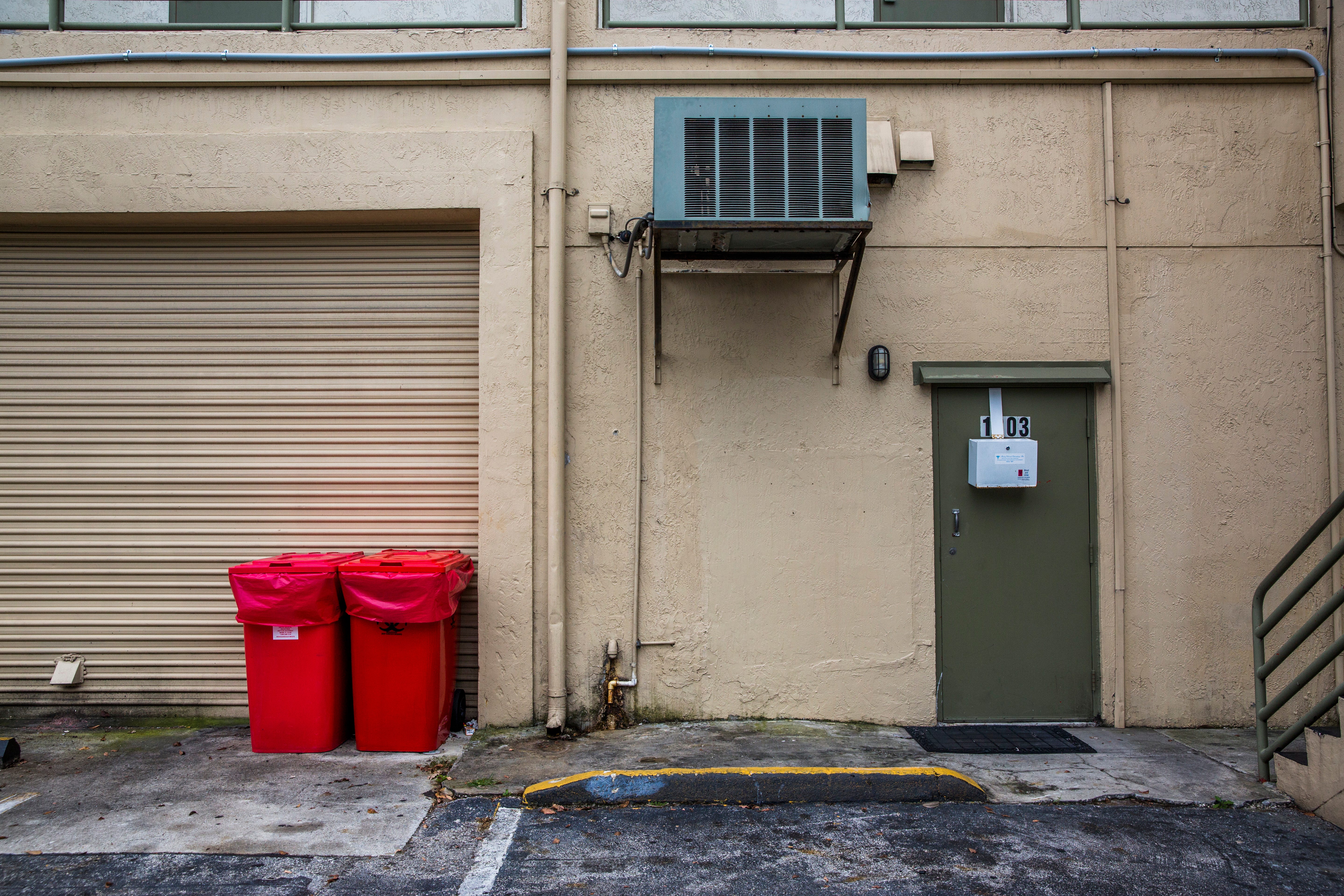 Biomedical waste containers in the parking area behind Jolie Plastic Surgery, where some patients are led into waiting taxis and ride services after surgeries.