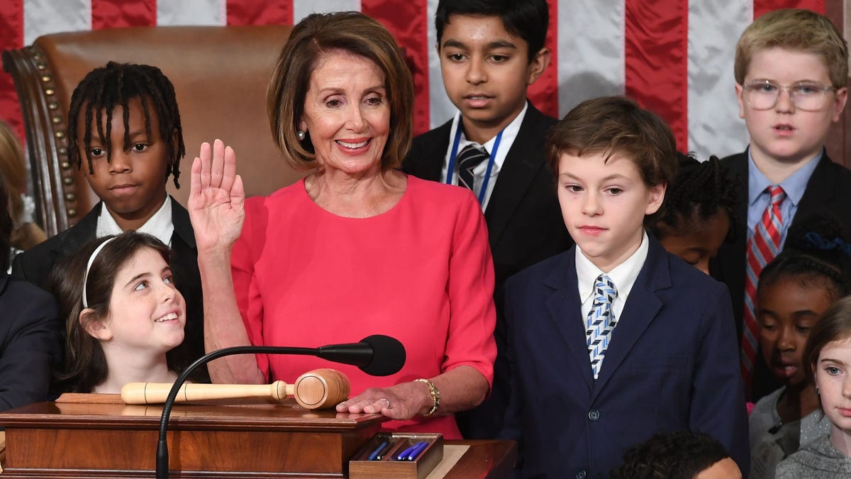 Incoming House Speaker Nancy Pelosi, D-CA, surrounded by children and grandchildren of lawmakers, raises her hand at the closing of the opening of the 116th Congress at the US Capitol in Washington, DC, January 3, 2019.