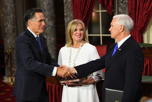 Senator Mitt Romney shakes the hand of Vice President Pence during his ceremonial swearing in as wife Ann Romney looks on.