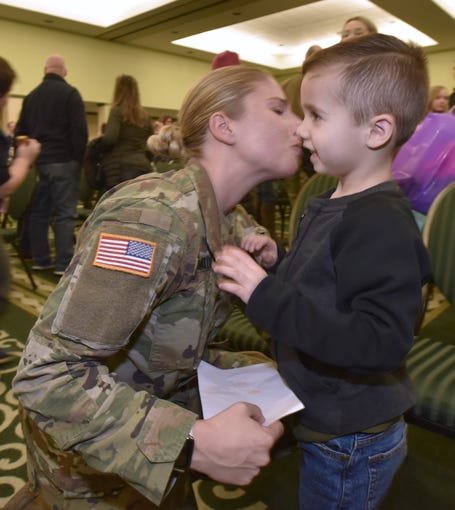 2nd Lt. Emma Smith gives a kiss to her nephew Madden Menchinger, 4.